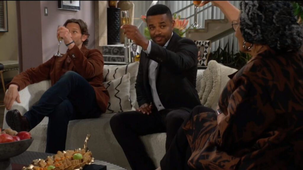 Daniel, Nate, and Mamie raise their glasses in a toast.