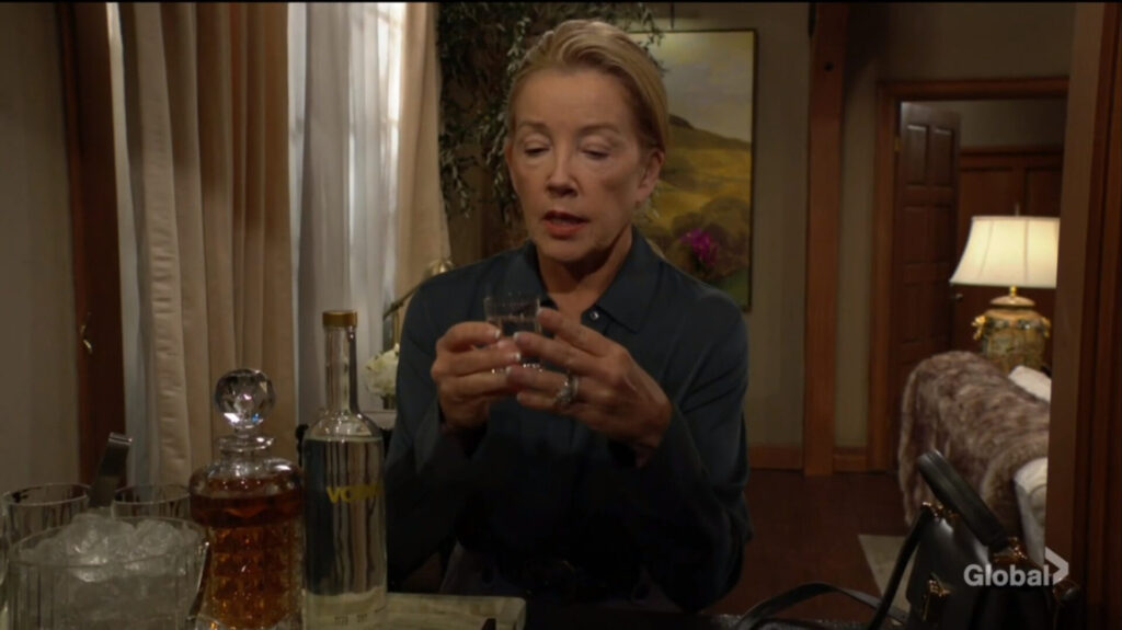 Nikki holds a shot glass full of vodka.