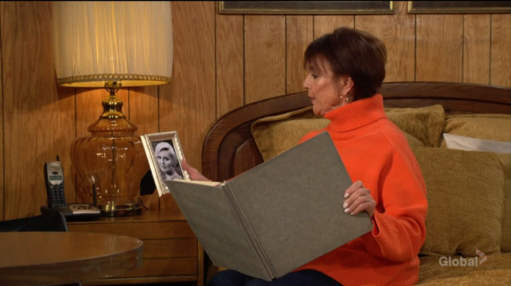 Jordan looks at a picture of Eve as she flips through a photo album.