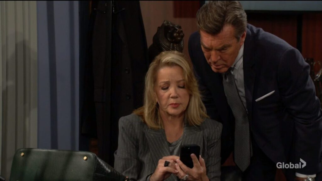 Nikki and Jack look at Nikki's phone.