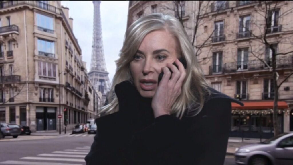 Ashley talks on the phone with the Eiffel Tower in the background.