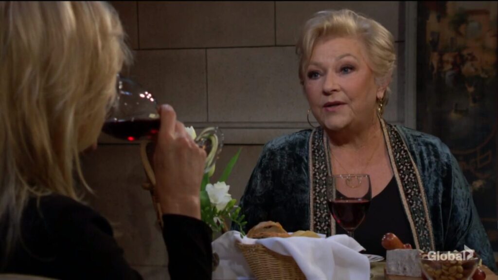 Ashley takes a sip of wine as she talks with Traci.