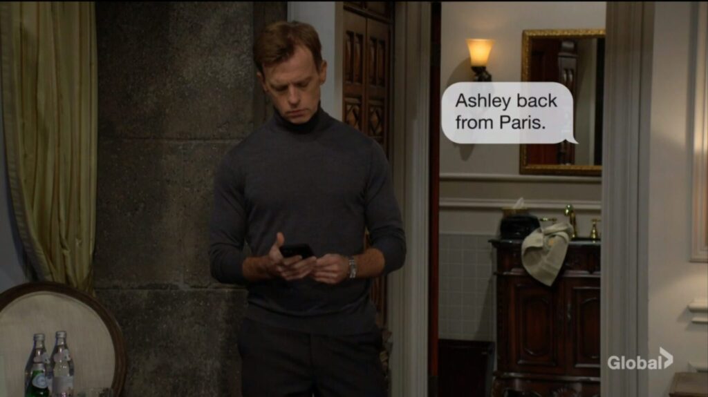 Tucker receives a text message. "Ashley back from Paris."