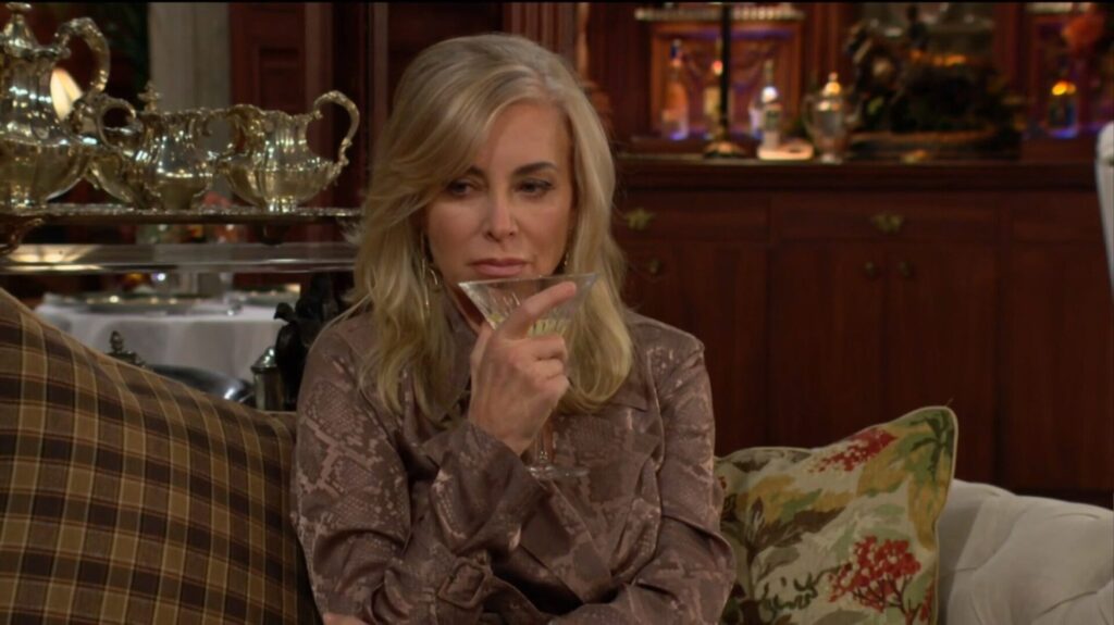 Ashley takes a drink of her martini.