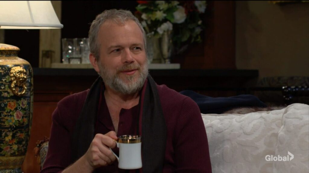 Seth holds a cup of coffee.