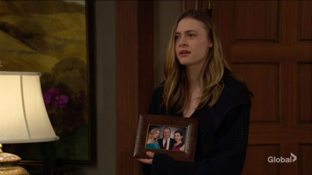 Claire Grace holds a photograph of Abby, Victor, and Victoria.
