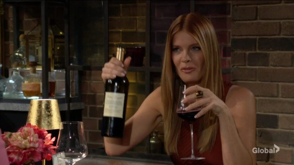 Phyllis holds up a bottle of wine as she drinks.