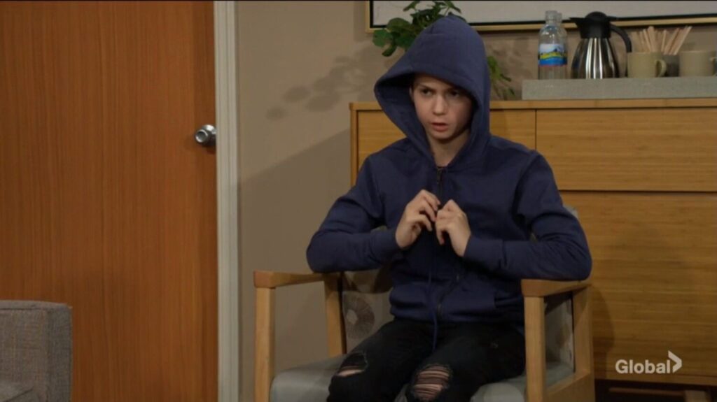 Connor plays with his hoodie as he talks.