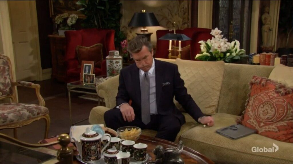Jack Abbott sits on the couch and cleans up.