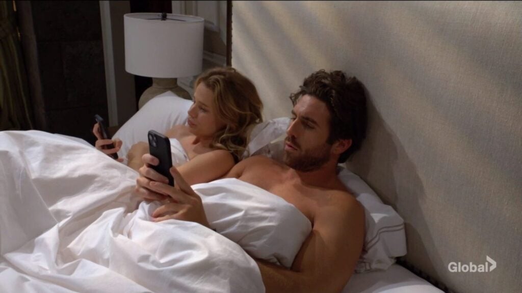 Summer Newman and Chance Chancellor lie in bed and look at their phones.