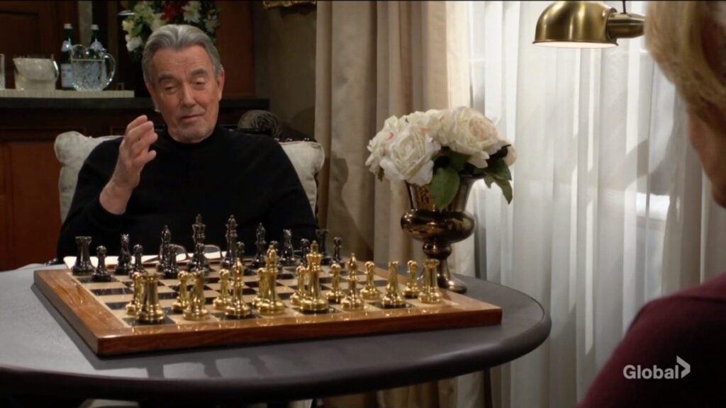 Victor Newman sits in front of a chess board and talks to his wife.