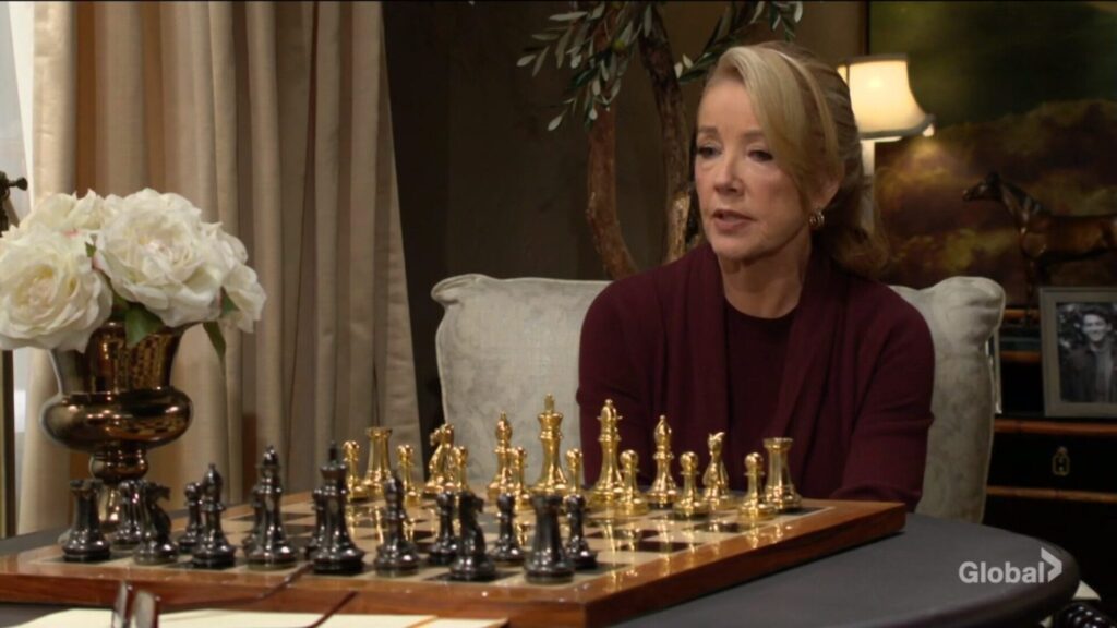 Nikki looks at the chessboard and talks to Victor.