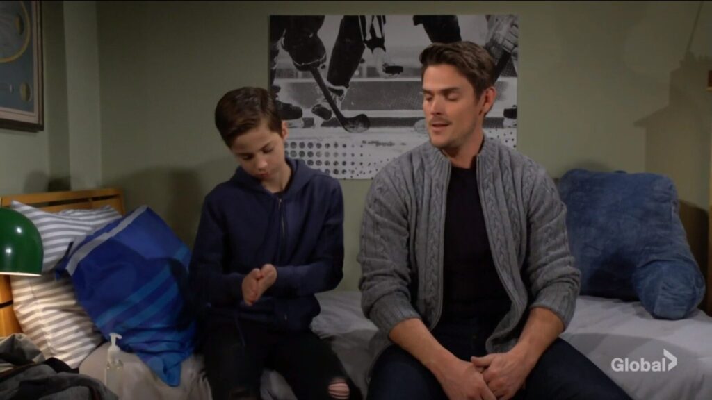 Connor and Adam Newman sit on the bed and talk.