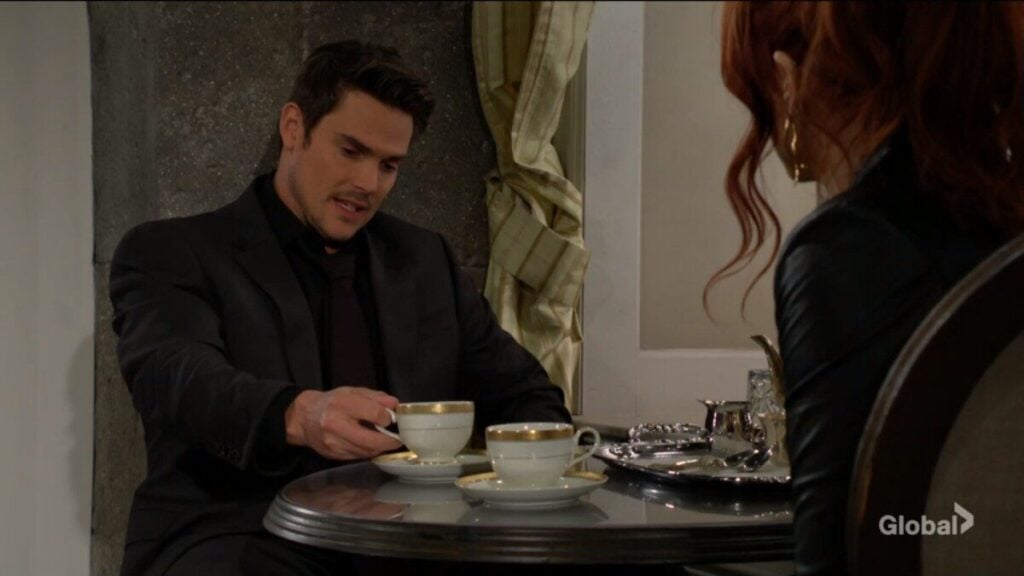 Adam and Sally sit and talk over coffee.