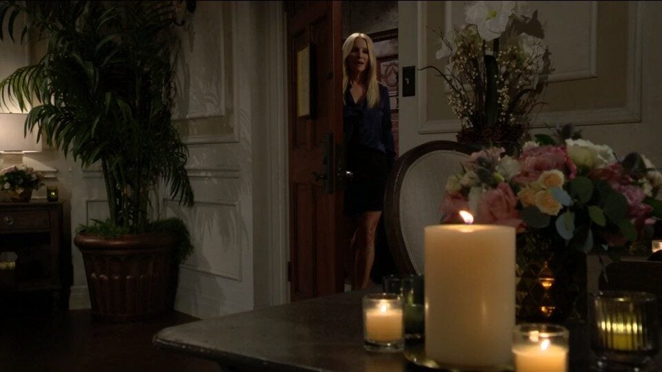 Christine looks through the door at candles and flowers.