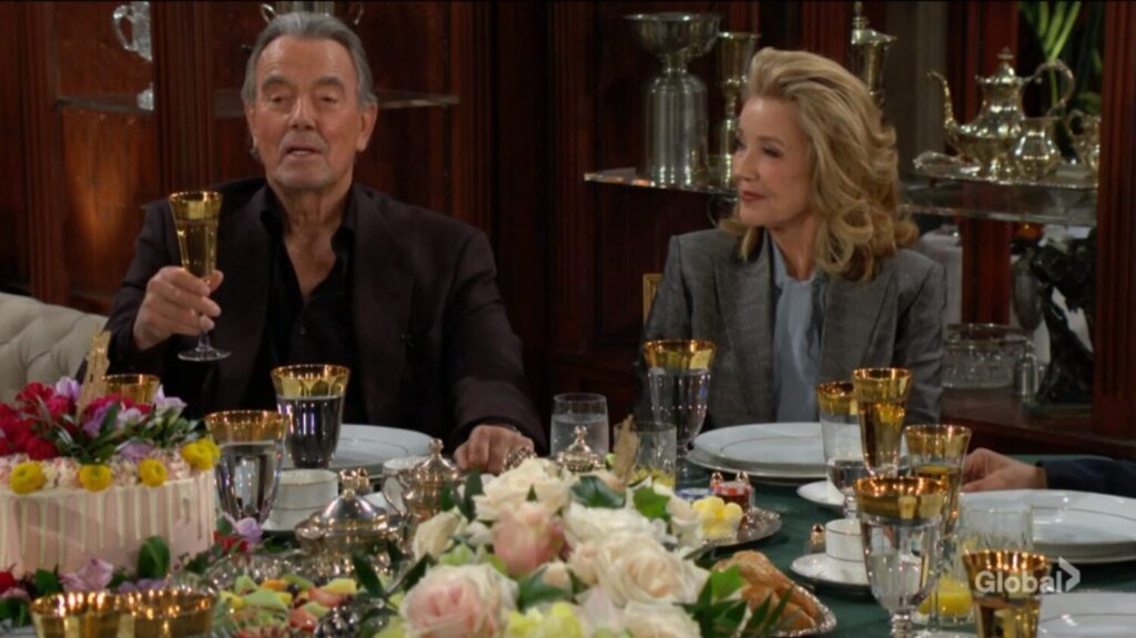 Victor Newman raises his glass in a toast as Nikki smiles beside him.