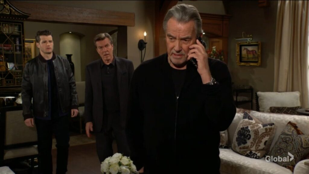 Victor Newman talks on the phone as Kyle and Jack Abbott look on.