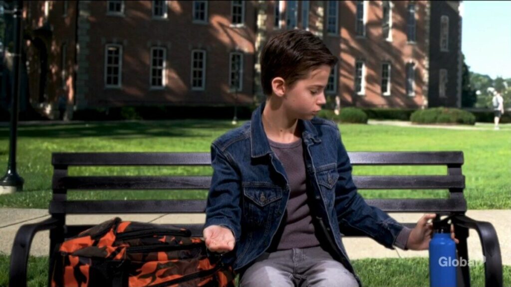 Connor Newman sits on a bench in front of the residential facility.